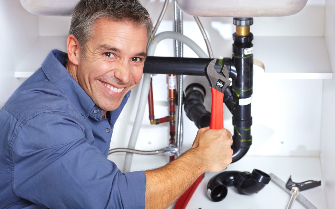 Handsome smiling plumber at the kitchen. Reparation. in Monks Corner, SC.